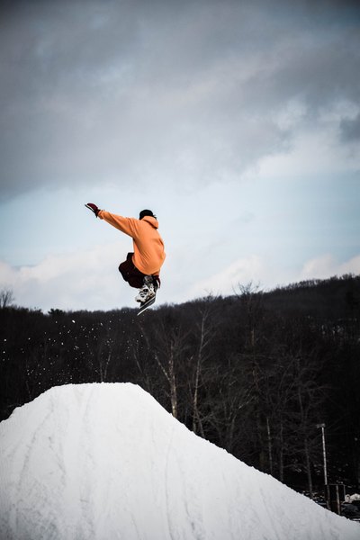 Snowboarder realizando un salto sobre una rampa nevada